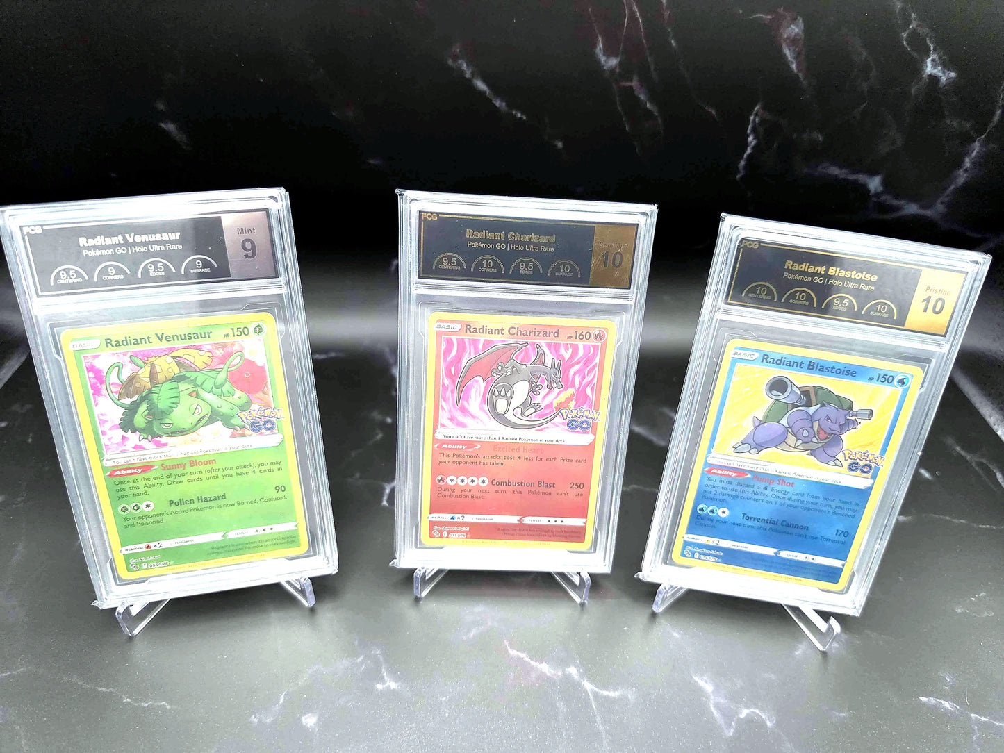 Three PCG-graded Radiant Pokémon GO cards — Venusaur, Charizard and Blastoise