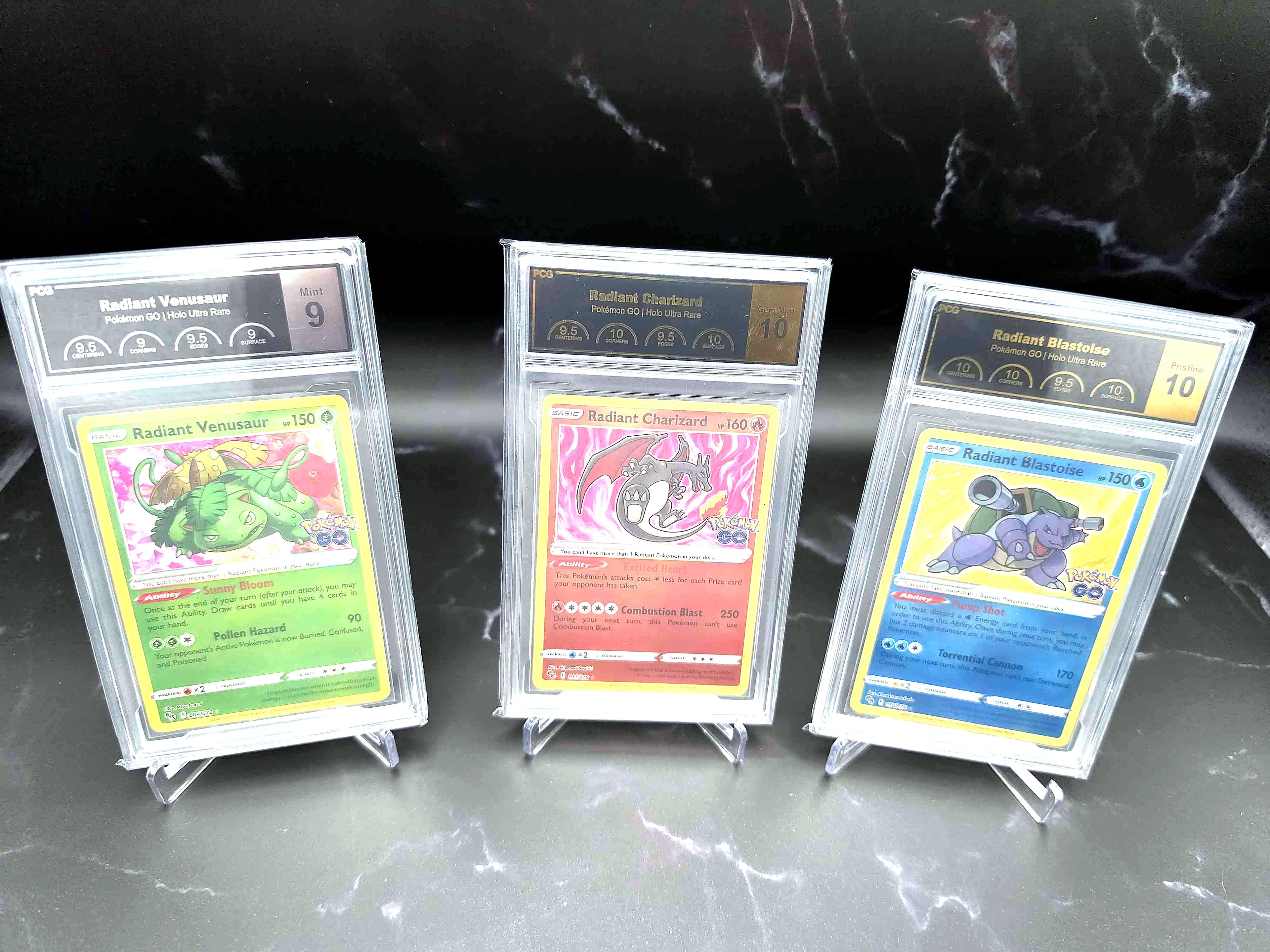 Three PCG-graded Radiant Pokémon GO cards — Venusaur, Charizard and Blastoise